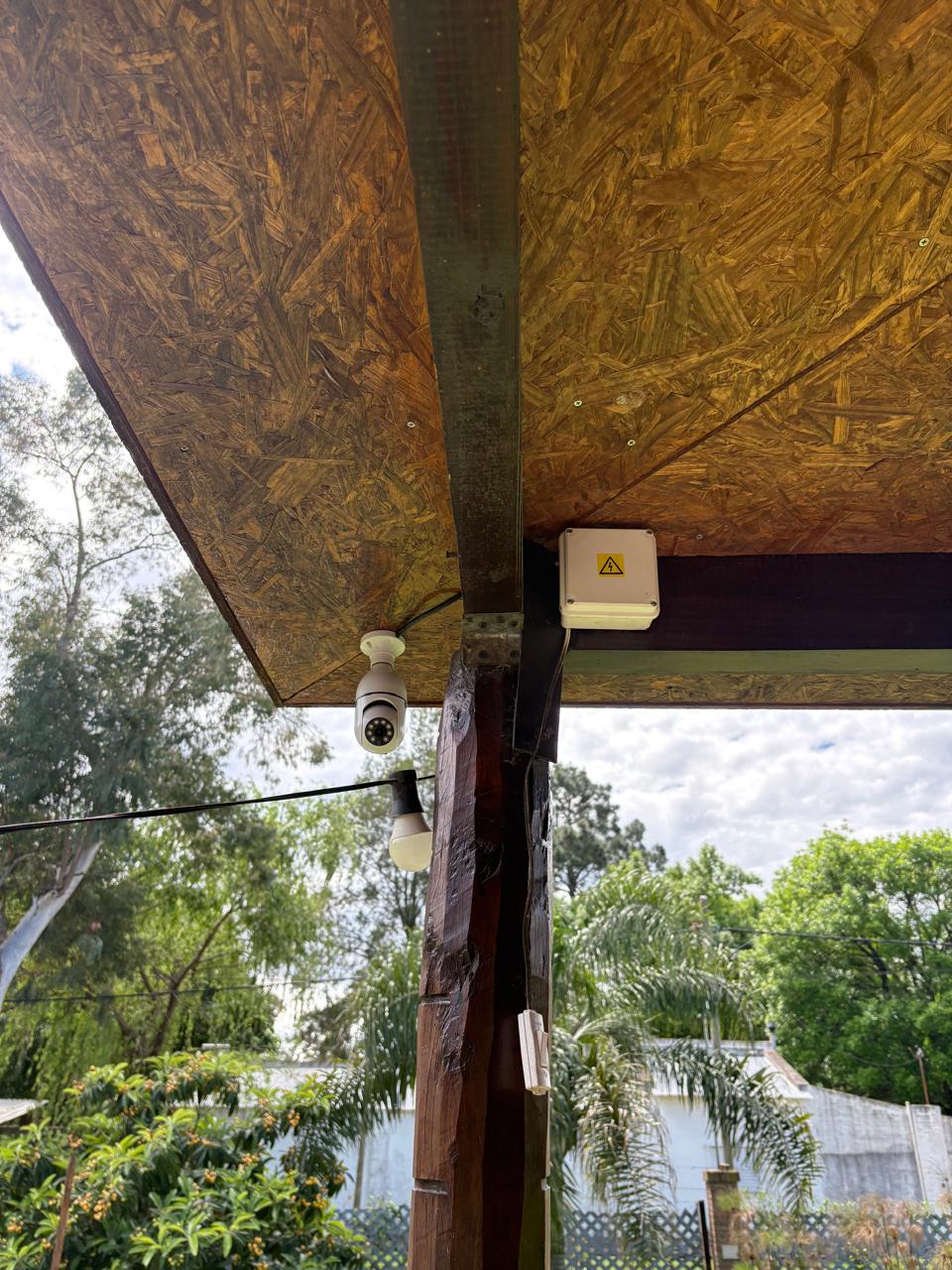 Cámara wifi bajo el alero de una galería, con caja eléctrica